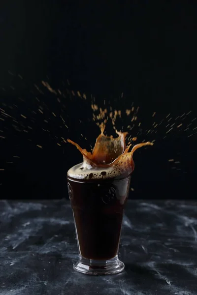 Koffie Splash Een Glas Koude Koffie Een Zwarte Achtergrond — Stockfoto
