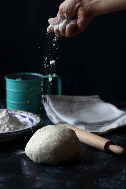 Hamur, siyah arka planda un, ekmek ve pizza hamuru ile hamur.