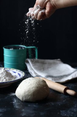 Hamur, siyah arka planda un, ekmek ve pizza hamuru ile hamur.