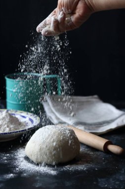 Hamur, siyah arka planda un, ekmek ve pizza hamuru ile hamur.