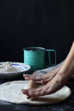 Hamur, siyah arka planda un, ekmek ve pizza hamuru ile hamur.