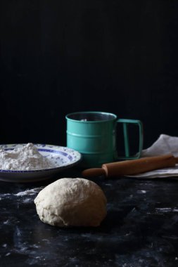 Hamur, siyah arka planda un, ekmek ve pizza hamuru ile hamur.