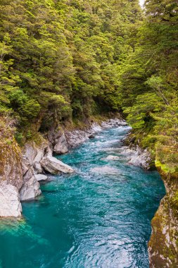 Kayaların arasında küçük, güzel ve hızlı bir nehir. Güney Adası, Yeni Zelanda