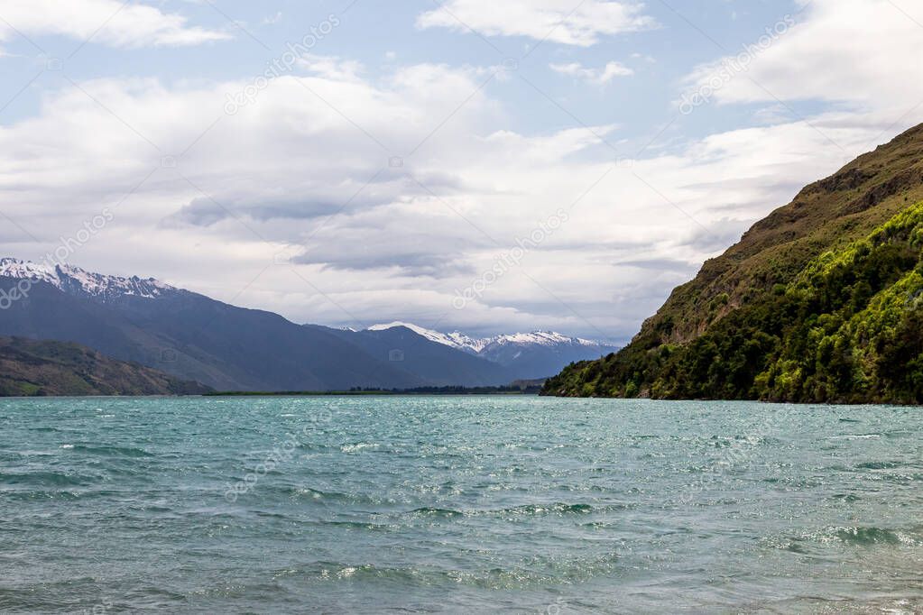 Snow and cliffs, stones and water. Wanaka lake. South Island, New Zealand