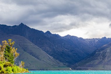 Turkuaz suyun üzerindeki dağ zirveleri. Wakatipu Gölü, Yeni Zelanda