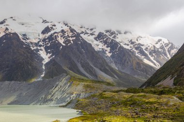 Suyun üzerindeki karlı dağlar. Muller Gölü. Güney Adası, Yeni Zelanda