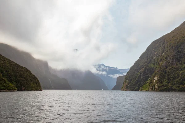 Fjordland 'in manzaraları. Bulutlardaki karlı dağlar. Yeni Zelanda