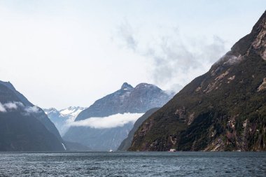 Bulutlardaki görkemli zirveler. Fiordland Ulusal Parkı. Güney Adası, Yeni Zelanda