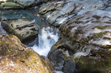 Yeni Zelanda 'da uçurum çökmesi. Taşların arasında akarsu. Güney Adası