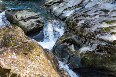Bir akarsu bacanın içinde kayboluyor. Funnel Chasm. Yeni Zelanda 'daki itfaiyeciler. Taşların arasında akarsu. Güney Adası