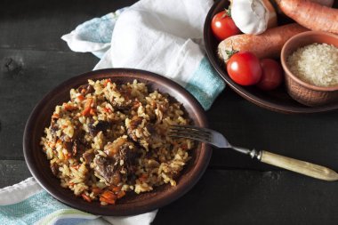 Plov ve koyu ahşap arka plan bir tabağa maddeler.