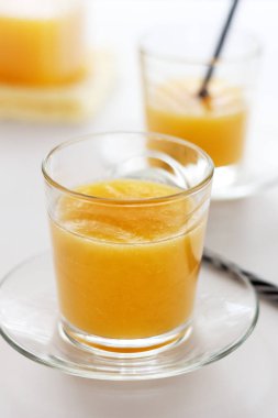 Beyaz bir masada iki bardak portakal suyu.