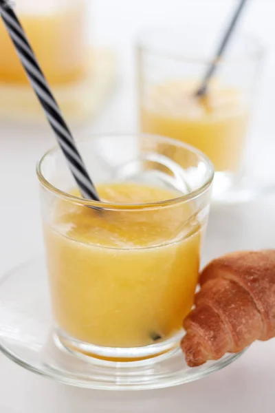 Deux verres de jus d'orange rafraîchissant sur une table blanche — Photo