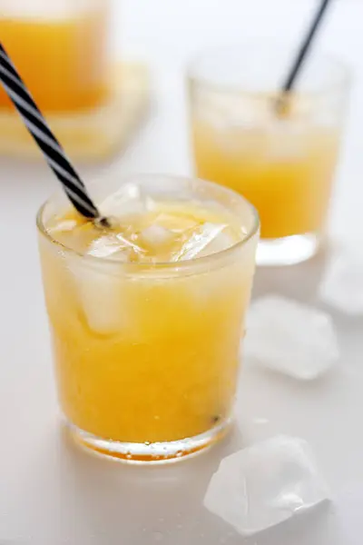 Two glasses of refreshing orange juice on a white table — Stock Photo, Image