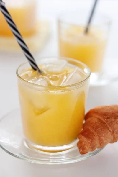 Deux verres de jus d'orange rafraîchissant sur une table blanche — Photo