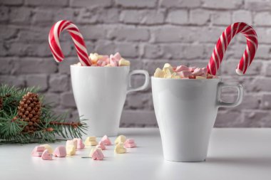 Marşmelov ve beyaz bir masada bir fincan latte.