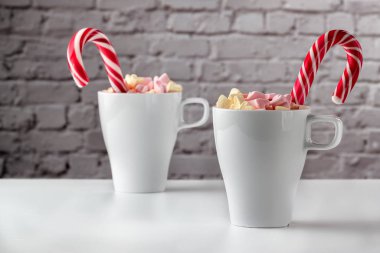 Marşmelov ve beyaz bir masada bir fincan latte.