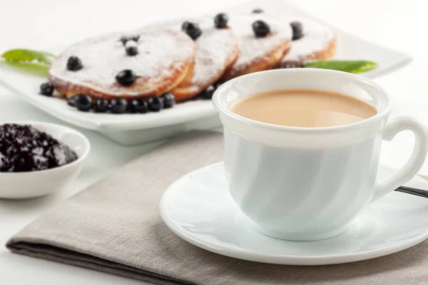 Чашка кави з молоком і тарілкою з млинцями на столі . — стокове фото