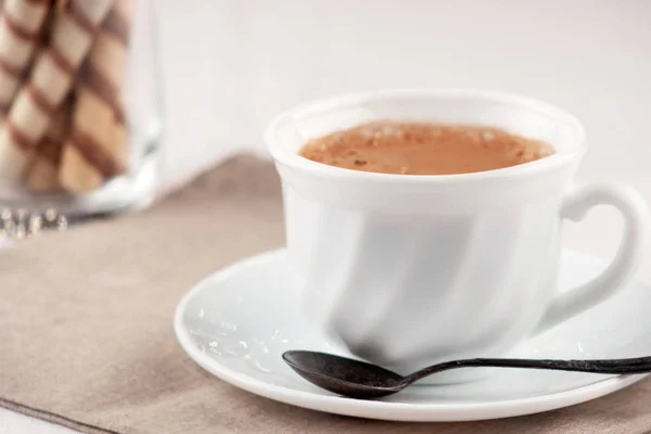На столе чашка свежего ароматного кофе со сладкими трубками — стоковое фото