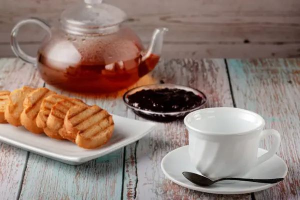 Свіжий чай в чайнику з печивом і варенням на столі — стокове фото