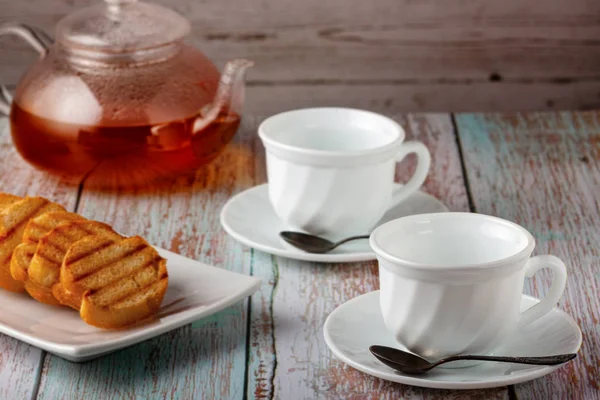 Té recién hecho en una tetera con galletas y mermelada en la mesa — Foto de Stock