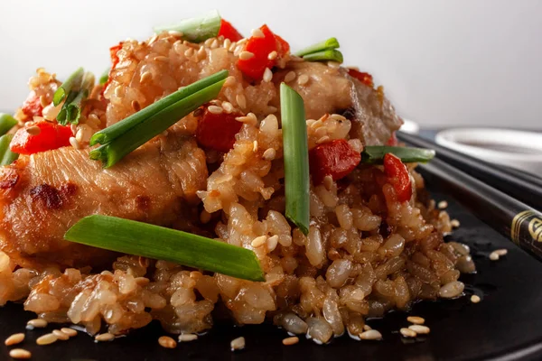 Tori chahan fried Japanese rice with vegetables and chicken in soy sauce in a black plate on a serving board — 图库照片