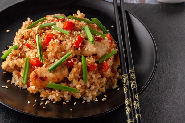 Tori chahan fried Japanese rice with vegetables and chicken in soy sauce in a black plate on a serving board — 图库照片