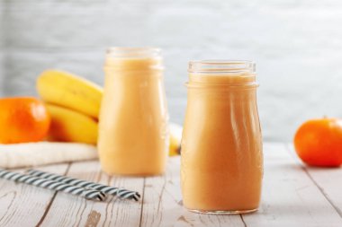 Mandalina ve muz suyu ahşap masada.