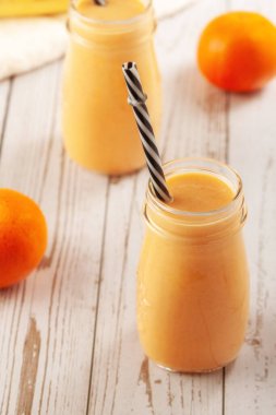 Mandalina ve muz suyu ahşap masada.