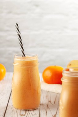 Mandalina ve muz suyu ahşap masada.