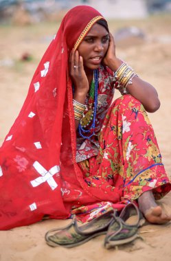 Bir Bhopa kadını, Hindistan, Rajasthan 'daki Pushkar Camel Fair' de şarkıcılarıyla birlikte ziyaretçileri ağırlıyor.