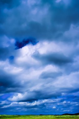 İrlanda tepelerinin üzerinde yuvarlanan bulutlarla panoramik manzara.