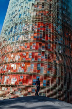 An adult man admiring the Torre Glories (Glories Tower) in Sant Marti district, Barcelona, Spain. 
