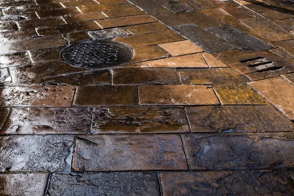 Wet old stone-paved flooring in Plaa Del Pi (Pine Square), Barcelona, Spain.