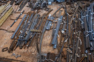 İnşaat alanındaki malzeme deposunun tepesinden bak. Çelik takviye çubukları istiflenmiş, sınıflandırılmış ve iş bekliyor. İtalya 'nın Milano şehrinde gökdelen yapım aşamasında