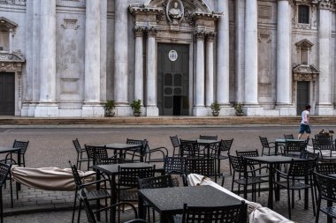 Resim, Brescia 'da Paul VI meydanındaki Yeni Katedral' in önünde terk edilmiş masa ve sandalyeleri gösteriyor. İtalya 'da koronavirüs salgını nedeniyle alınan tecrit tedbirleri 3 Mayıs' a kadar uzatılacak.