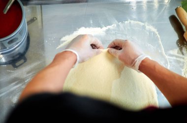 Fırıncı pizza hamuru hazırlar. Hamur yoğuran fırıncının eli