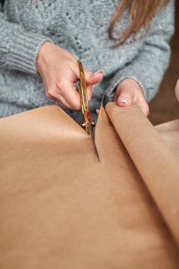 Genç kız hediye yapmak için kâğıt kesiyor.