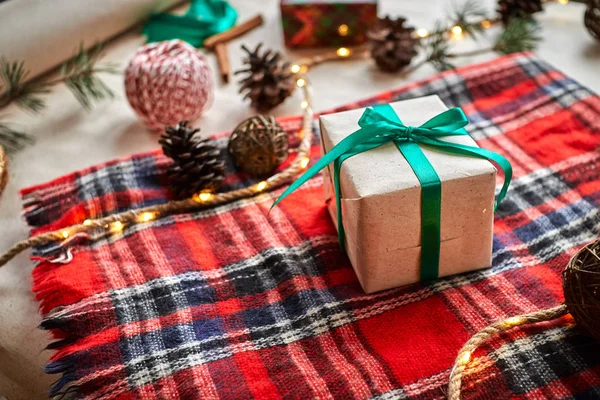 Weihnachtsgeschenke Auf Dem Hintergrund Eines Rotwollkarierten Karos Mit Girlanden Aus — Stockfoto