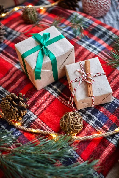 Weihnachtsgeschenke Auf Dem Hintergrund Eines Rotwollkarierten Karos Mit Girlanden Aus — Stockfoto