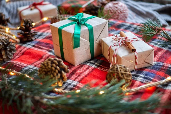 Weihnachtsgeschenke Auf Dem Hintergrund Eines Rotwollkarierten Karos Mit Girlanden Aus — Stockfoto