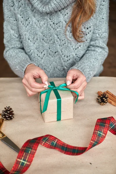 Руки Женщины Пуловере Держат Рождественскую Подарочную Коробку Украшенную Вечнозеленой Веткой — стоковое фото