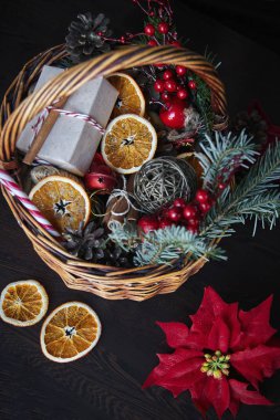 Noel sepeti çizgili şeker kamışları, dilimlenmiş portakallar, koniler ve hediyeler.