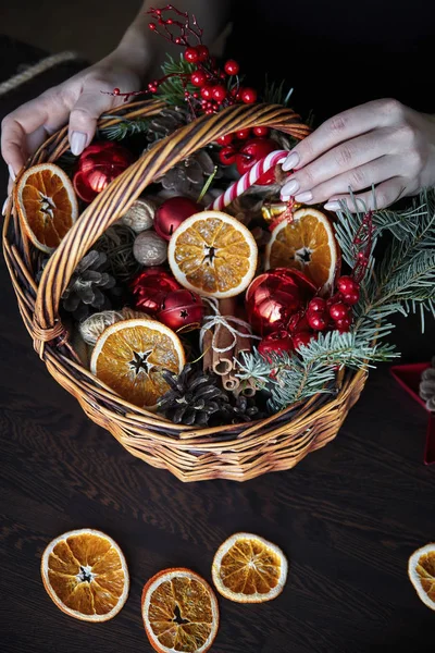 Die Weibliche Hand Sammelt Einen Weidenkorb Mit Weihnachtsdekoration Und Waren — Stockfoto