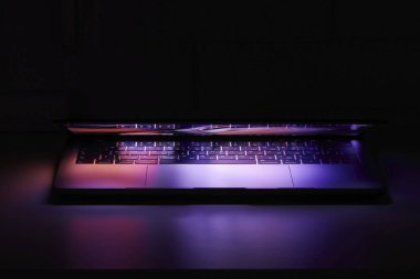 Saratov / Rusya - 21 Mart 2020: Bir MacBook Pro ve renkli duvar kağıdının fotoğrafı, ekran neredeyse kapatıldı