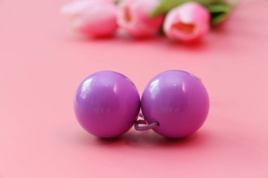 Pink vaginal balls on a pink background. clipart