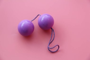 Pink vaginal balls on a pink background. clipart