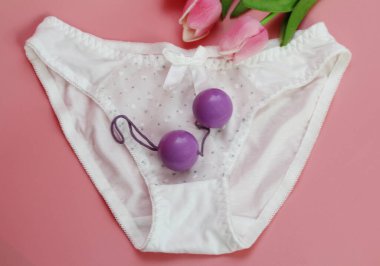 Double pink vaginal balls lie on the panties. clipart