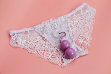 Double pink vaginal balls lie on the panties. clipart