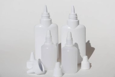 Arka planda bir sürü beyaz plastik şişe var..